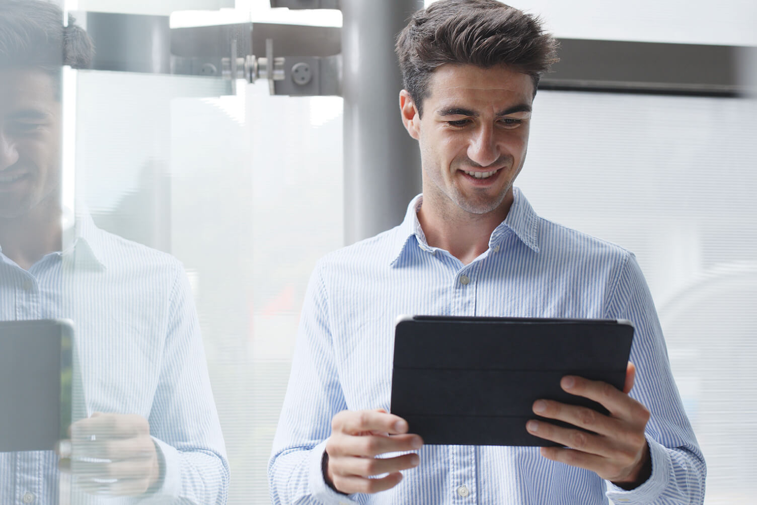 Hombre sonriendo viendo una tablet.