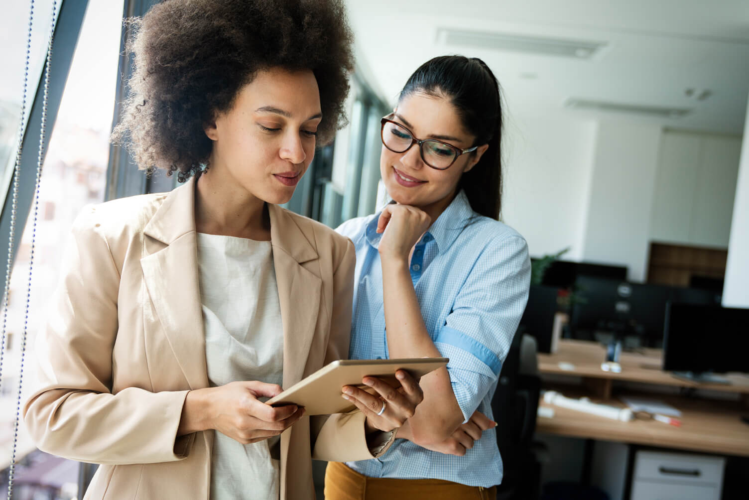 Dos mujeres viendo información de una tablet.